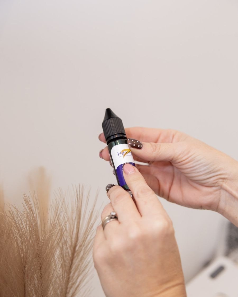 Vicki holding a bottle of cosmetic tattoo pigment